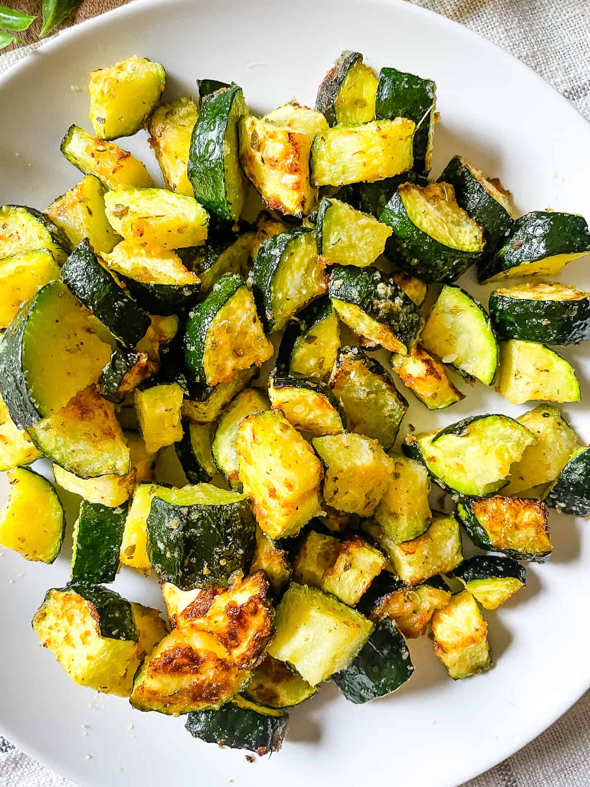 Freshly made air fryer roasted zucchini on a white plate