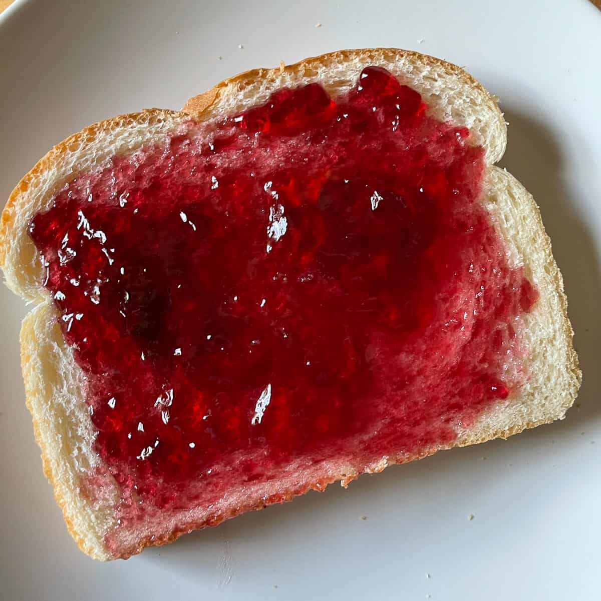 slice of white bread with grape jelly