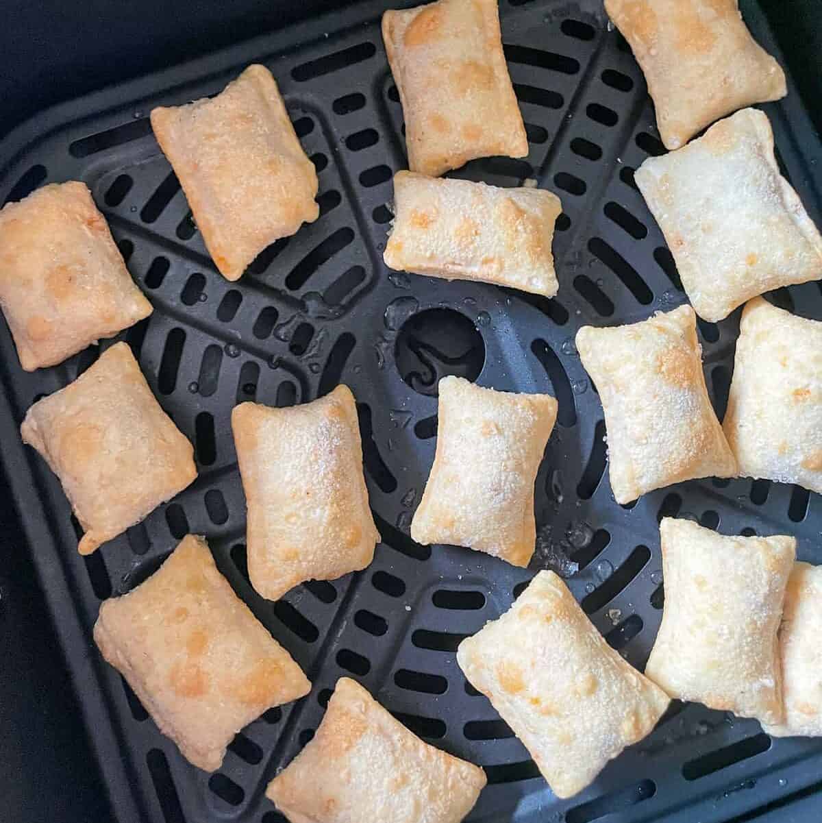 frozen pizza rolls in a single layer in air fryer basket